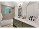 This bathroom features a double vanity with modern fixtures, sleek mirrors, and a shower-tub combo at 10863 W 67Th Pl, Arvada, CO 80004