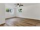 Bright bedroom features hardwood floors, a ceiling fan, and multiple windows for ample natural light at 10863 W 67Th Pl, Arvada, CO 80004