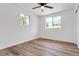 Bright bedroom with hardwood floors, a ceiling fan, and two windows offering natural light at 10863 W 67Th Pl, Arvada, CO 80004