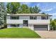 Well-maintained two-story home with a manicured front lawn and gray door at 10863 W 67Th Pl, Arvada, CO 80004
