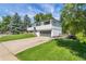 Exterior view of home with mature trees, manicured lawn, and long driveway at 10863 W 67Th Pl, Arvada, CO 80004