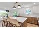 Kitchen island with seating area and modern hanging light fixtures at 10863 W 67Th Pl, Arvada, CO 80004