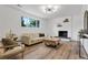 Cozy living room featuring hardwood floors, a fireplace with shelving, and neutral-toned furniture at 10863 W 67Th Pl, Arvada, CO 80004