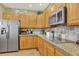 Bright kitchen with stainless steel refrigerator, cooktop, and ample cabinet space at 16367 E Auburn Hills Dr, Parker, CO 80134