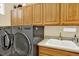 Functional laundry room featuring a washer, dryer, utility sink, and cabinet storage at 16367 E Auburn Hills Dr, Parker, CO 80134
