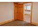 Bedroom featuring carpeting, a window, wood trim, and closet access at 5237 S Olive Rd, Evergreen, CO 80439