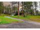 Scenic view of a green two-story home nestled on a lush hillside surrounded by mature pine trees at 5237 S Olive Rd, Evergreen, CO 80439