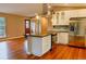 Open kitchen featuring stainless steel appliances, a large island, hardwood floors, and a view of the front door at 5237 S Olive Rd, Evergreen, CO 80439