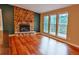 Cozy living room featuring a stone fireplace, hardwood floors, and a view of the trees outside at 5237 S Olive Rd, Evergreen, CO 80439