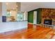 Open-concept living room with a stone fireplace, hardwood floors, and a view into the kitchen at 5237 S Olive Rd, Evergreen, CO 80439