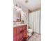 Cozy bathroom with a red vanity, decorative mirrors, and a shower with white curtain at 2279 Coronado Pkwy # B, Denver, CO 80229