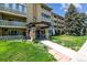 Inviting condo building showcasing professional landscaping, flags, and a covered entryway at 695 S Alton Way # 5A, Denver, CO 80247