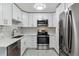 Modern kitchen features stainless steel appliances, white cabinetry and stylish backsplash at 695 S Alton Way # 5A, Denver, CO 80247