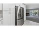 Kitchen with stainless steel refrigerator and white cabinets adjacent to the living area at 695 S Alton Way # 5A, Denver, CO 80247