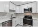 Bright kitchen boasts stainless steel appliances, a modern sink, and sleek white cabinets at 695 S Alton Way # 5A, Denver, CO 80247