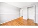 Simple bedroom featuring hardwood floors and a view out the window at 5202 Dillon St, Denver, CO 80239