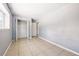 Bright bedroom with tile flooring, an open closet, and neutral colored walls at 5202 Dillon St, Denver, CO 80239