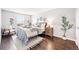 Bright bedroom featuring a cozy bed, hardwood floors, and natural light at 5202 Dillon St, Denver, CO 80239