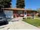 Charming brick ranch-style home featuring a well-manicured front yard and long driveway at 2213 S Meade Street, Denver, CO 80219