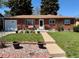 Charming brick ranch-style home featuring a well-manicured front yard and inviting front porch at 2213 S Meade Street, Denver, CO 80219