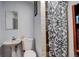 Simple bathroom with a pedestal sink, toilet, and a shower with patterned curtain at 4024 W Kentucky Ave # A And B, Denver, CO 80219