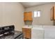 Practical laundry area features a sink, cabinets, appliances, and compact design at 4024 W Kentucky Ave # A And B, Denver, CO 80219