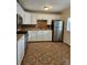 Updated kitchen featuring white cabinets, stainless steel appliances, and eye-catching patterned tile floors at 1390 Ash Ct, Thornton, CO 80229