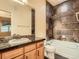 Stylish bathroom offers a dark granite vanity, shower with tile, and tub at 11316 Colony Cir, Broomfield, CO 80021