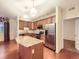 An open-concept kitchen with stainless steel appliances, hardwood floors and a center island at 11316 Colony Cir, Broomfield, CO 80021