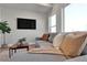 Inviting living room with a sectional, large windows, a wall-mounted TV, and natural accents at 2140 S Ash St # 104, Denver, CO 80222