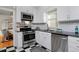 Modern kitchen with white cabinets, stainless steel appliances, and black and white floor at 1445 Elm St, Denver, CO 80220