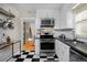 Stylish kitchen with stainless steel appliances and black and white checkered floor at 1445 Elm St, Denver, CO 80220