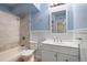 Bathroom featuring blue walls, white cabinets, shower and modern fixtures at 3663 S Sheridan Blvd # 2, Denver, CO 80235