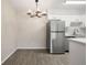 Dining area with gray vinyl flooring and modern chandelier at 3663 S Sheridan Blvd # 2, Denver, CO 80235