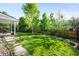 Lush backyard featuring manicured lawn, stone pathway and partial fence at 6829 S Niagara Ct, Centennial, CO 80112