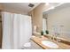 Well-lit bathroom with granite countertop, white sink and shower with a white curtain at 6829 S Niagara Ct, Centennial, CO 80112
