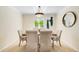 Elegant dining room featuring a modern light fixture, a view of the lush greenery outside, and comfortable seating for six at 6829 S Niagara Ct, Centennial, CO 80112