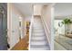 Hallway featuring hardwood floors, a staircase, and a view into the adjacent living spaces at 6829 S Niagara Ct, Centennial, CO 80112