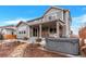 Beautiful backyard of gray two story home featuring a hot tub and covered patio with lights at 5253 Cherry Blossom Dr, Brighton, CO 80601