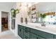 Elegant bathroom with a double vanity, green cabinets, and modern mirrors, enhanced by botanical accents at 5253 Cherry Blossom Dr, Brighton, CO 80601