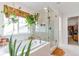 Luxurious bathroom featuring a soaking tub, a glass-enclosed shower, and stylish hanging plants at 5253 Cherry Blossom Dr, Brighton, CO 80601