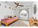 Cozy bedroom featuring a platform bed, a ceiling fan, and a large window providing neighborhood views at 5253 Cherry Blossom Dr, Brighton, CO 80601