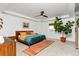 Bright bedroom with a modern platform bed, stylish rug, and a large potted tree by the window at 5253 Cherry Blossom Dr, Brighton, CO 80601