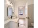 Bright bathroom featuring modern vanity with stylish mirror, contemporary lighting, and an open doorway at 3922 W 29Th Ave, Denver, CO 80212
