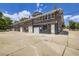 Exterior view of a multi-unit brick building with multiple garage doors and a large parking area at 3922 W 29Th Ave, Denver, CO 80212