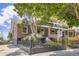 Beautiful brick home with a well-maintained lawn, wrought iron fence, and mature trees at 3922 W 29Th Ave, Denver, CO 80212
