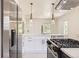 Updated kitchen features white cabinetry, marble countertops, pendant lighting, and stainless steel appliances at 3922 W 29Th Ave, Denver, CO 80212