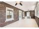 Bright sunroom with exposed brick, large windows, ceiling fans, and light wood flooring at 3922 W 29Th Ave, Denver, CO 80212