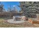 Cozy backyard firepit area, surrounded by mature trees and landscaping at 6259 S Fenton Ct, Littleton, CO 80123