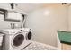 Laundry room with white front load washer and dryer with nearby sink at 6259 S Fenton Ct, Littleton, CO 80123